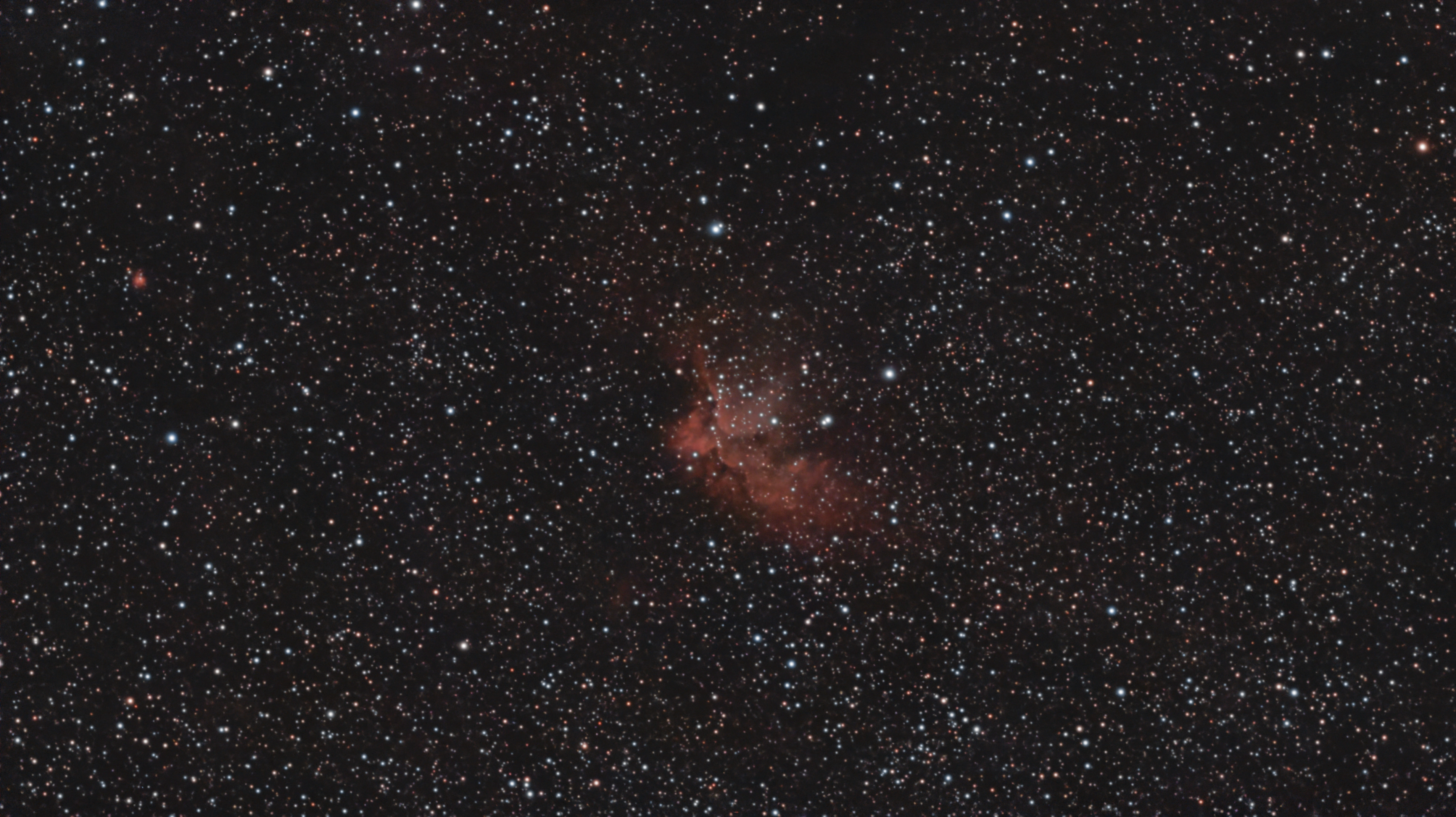 The Wizard Nebula, NGC 7380, glowing among a dense star field